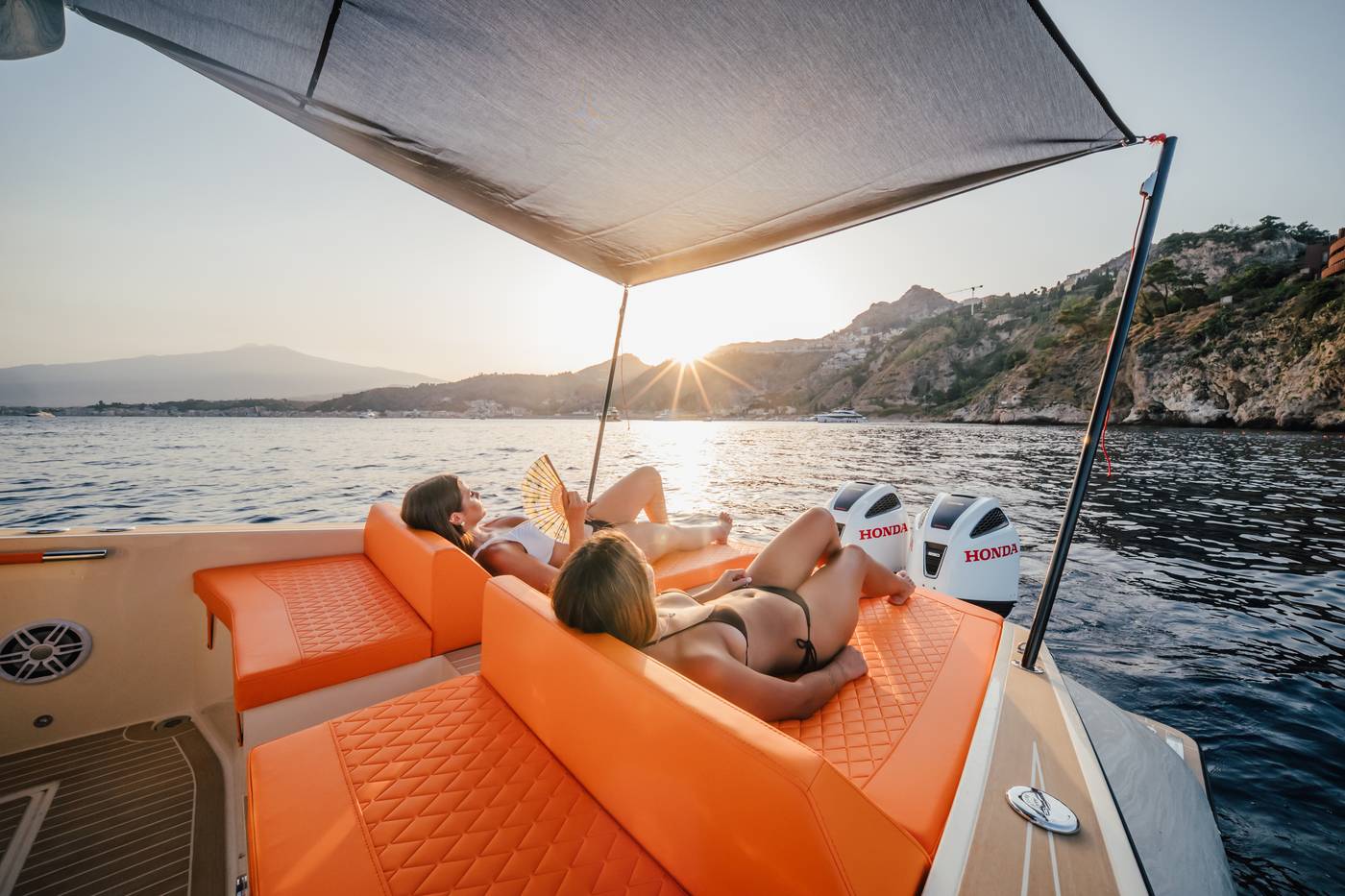 Espérée — prendisole di poppa sotto il tendalino esteso, al tramonto